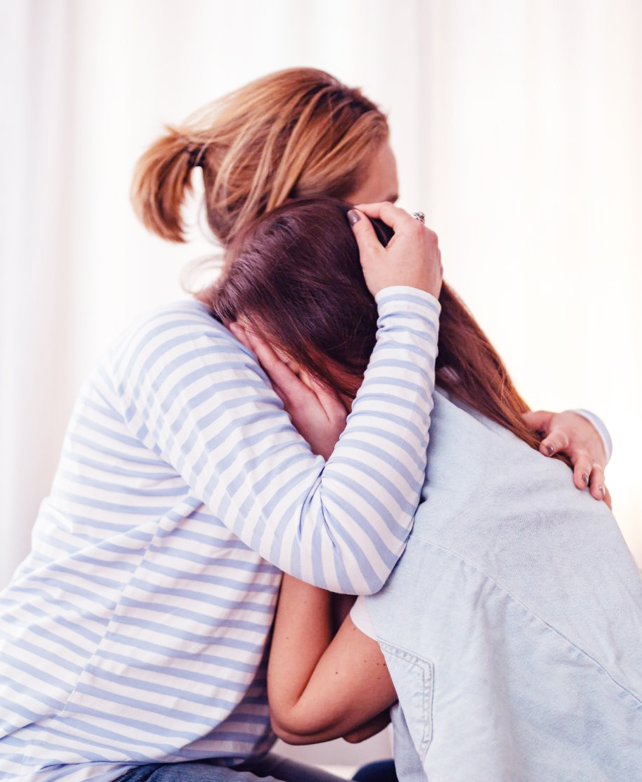 Mother and upset teenage daugher hugging